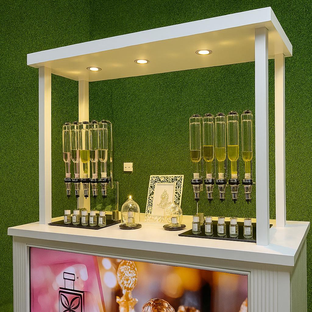 Perfume Booth setup in Dubai featuring a branded fragrance bar with colorful dispensers, interactive screen, and artificial grass backdrop for events and exhibitions